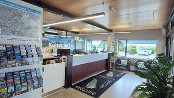 A reception area with a map, informational brochures, a reception desk, seating area, and a view of the outside.