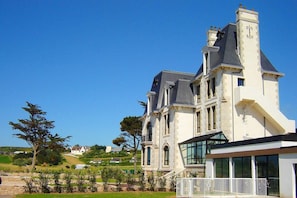 A large, historic building with a prominent tower and multiple windows, surrounded by a well-maintained garden. - Apartment in Plougasnou with Stunning Sea Views (Plougasnou)
