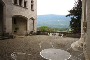 A courtyard with stone walls, a gravel floor, and outdoor seating. - House in France with Pool and Views (Serrieres en Chautagne)