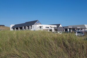 A modern building with a flat roof and a sign that reads 'La Table D'Eux.' - Seaside Apartment Stay (Guidel)