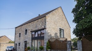 A stone house with a large window, a gated driveway, and a parked car. - Tranquil Stay in Ardennes (Gimnée)