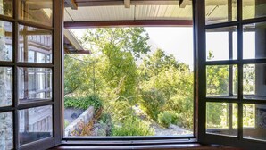Ein Zimmer mit großem Fenster und Blick auf einen Garten.