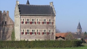 Un edificio storico con facciata simmetrica, numerose finestre e una torre imponente.