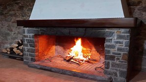 Ein Steinkamin mit weißem Sims und einem Feuer darin.