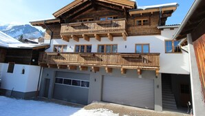 Un immeuble à plusieurs étages doté de balcons en bois et d’un garage.