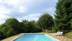 A rectangular swimming pool with a tiled edge, surrounded by lush greenery and trees. - Lovely Villa in La Coquille with Swimming Pool (La Coquille)