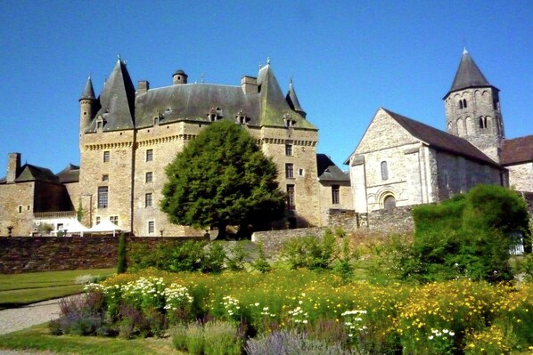 A historic stone castle with multiple towers and a church.