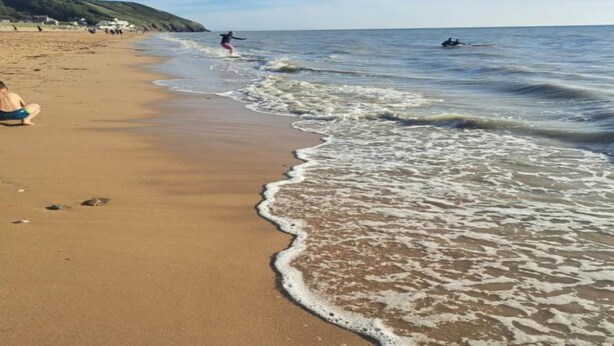 A sandy beach with gentle waves, a clear sky, and distant hills. - Peaceful Stay near Lake (Montgothier)