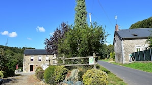 A stone building with a wooden fence, a gravel path, and a road. - Peaceful Stay near Lake (Montgothier)