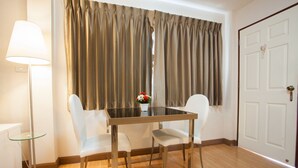 Un rincón de comedor con una mesa, sillas, una lámpara de pie y una puerta.