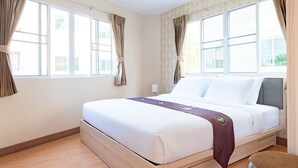 Una habitación de hotel con una cama grande, cortinas y una ventana.