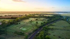 Eine Vogelperspektive auf einen Golfplatz, durch den eine Straße führt.