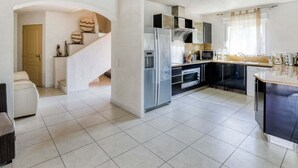 Een moderne keuken met een centraal eiland, roestvrijstalen apparatuur en een ingebouwde oven.