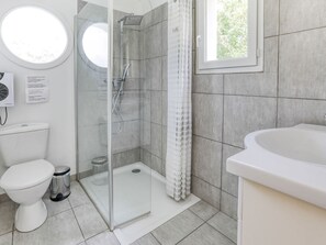 Une salle de bain moderne équipée d’une douche, de toilettes et d’un lavabo.