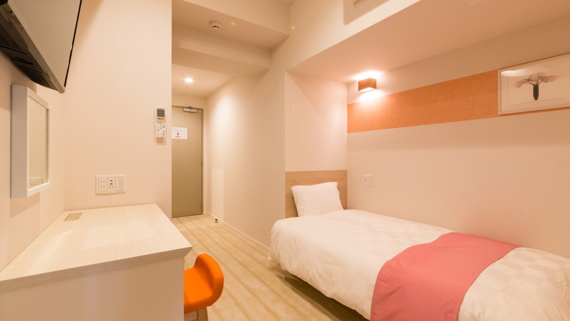 Habitació d'hotel amb llit, escriptori, cadira i zona de banyera.