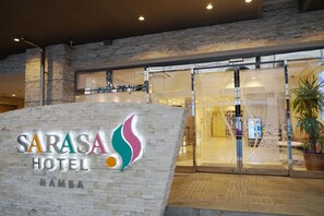 The exterior of Sarasa Hotel with a stone facade and a glass entrance. - Sarasa Hotel Namba (Osaka)