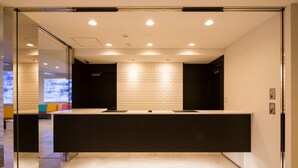 Ein Empfangsbereich modernen Designs mit einer Rezeption, Glastrennwänden und einer Wand mit Musterung.