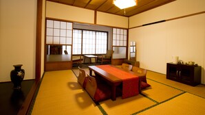 Una habitación japonesa tradicional con suelo de tatami, una mesa de madera baja y puertas correderas shoji.