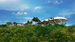A modern house with a large white umbrella-like structure on the roof, surrounded by lush greenery. - Ultra Winds Mountain Resort (Baungon)