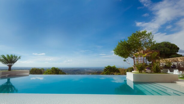A clear blue infinity pool with a view of the horizon. - Ultra Winds Mountain Resort (Baungon)