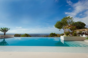 A clear blue infinity pool with a view of the horizon. - Ultra Winds Mountain Resort (Baungon)