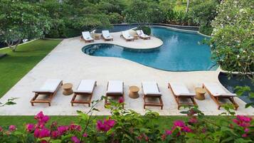 Una piscina al aire libre, tumbonas