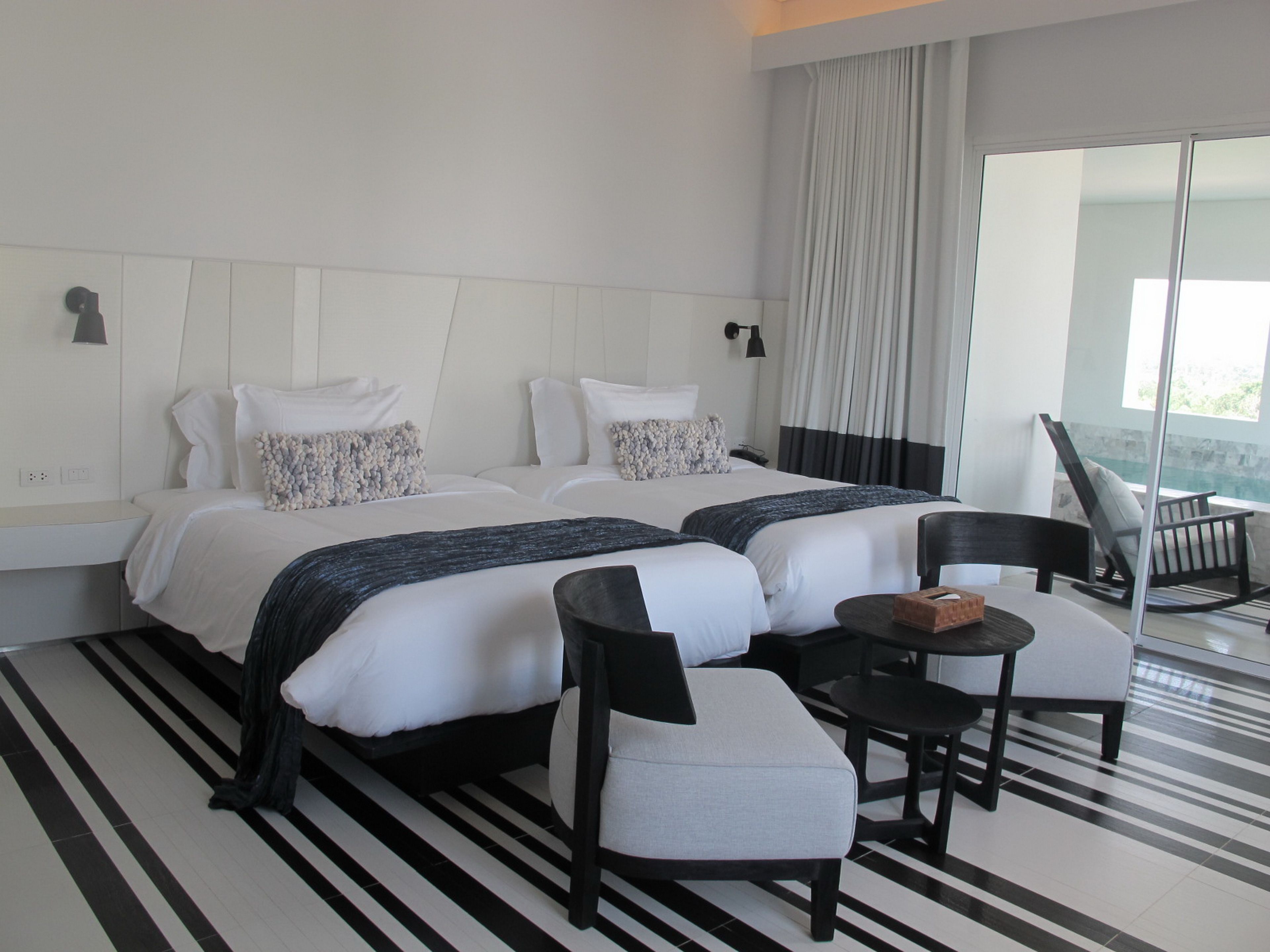 Ein Hotelzimmer mit zwei Betten, einem kleinen Tisch und einem Stuhl.