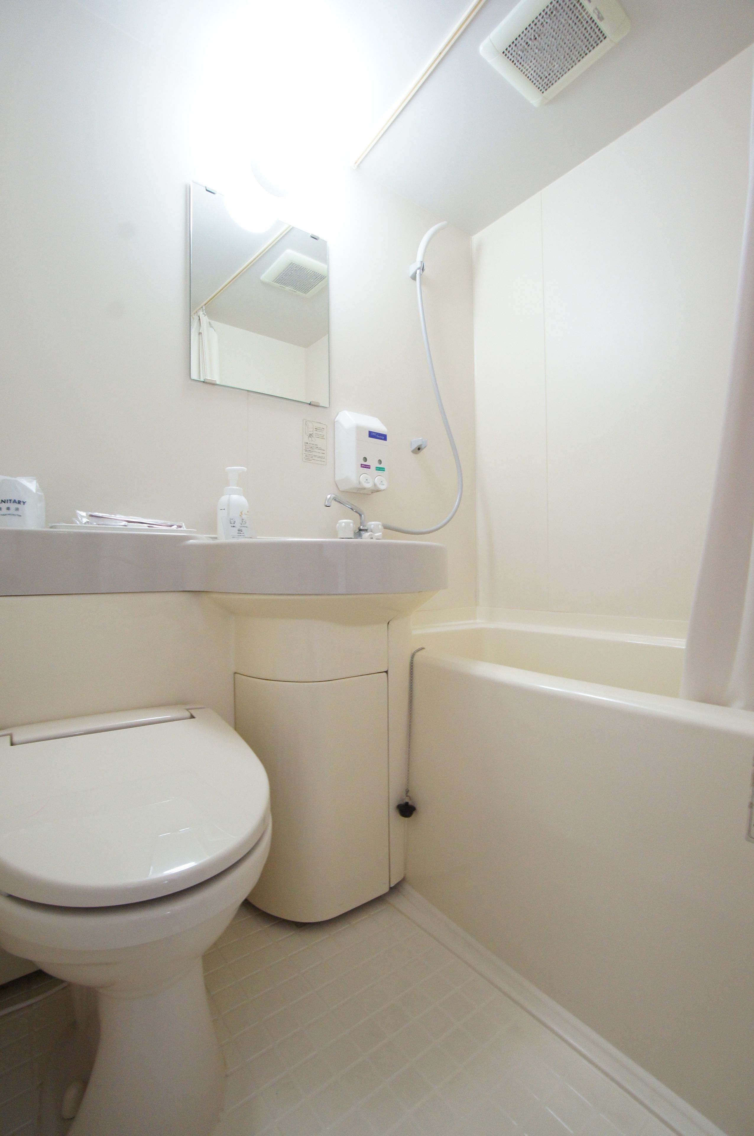 A small, clean bathroom with a toilet, sink, and shower.
