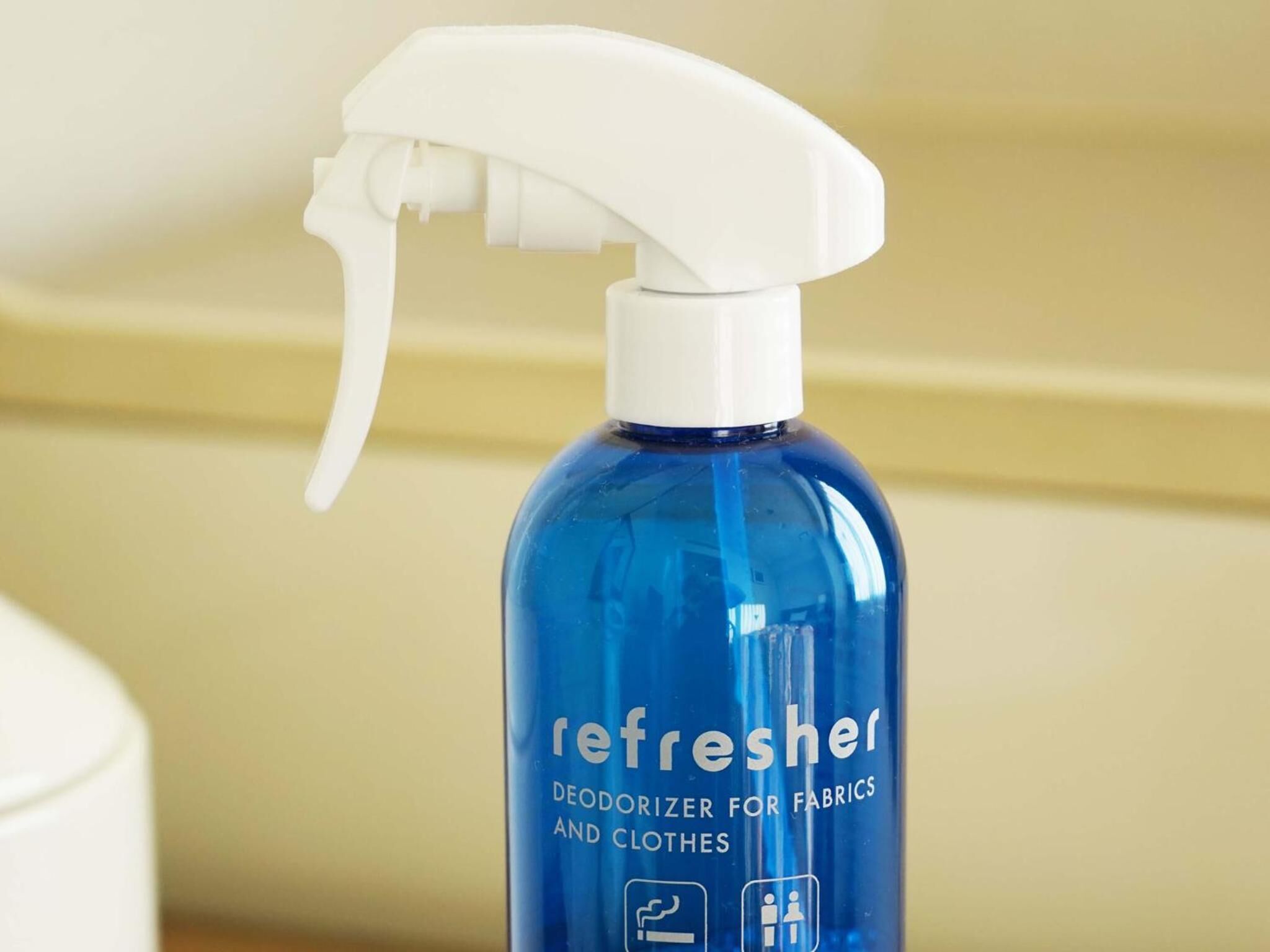 Una bottiglia blu di deodorante per tessuti e abbigliamento 'Refresher'.