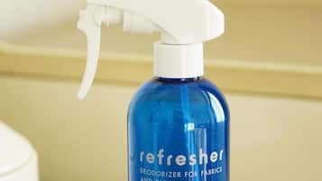 Una bottiglia blu di deodorante per tessuti e abbigliamento 'Refresher'.