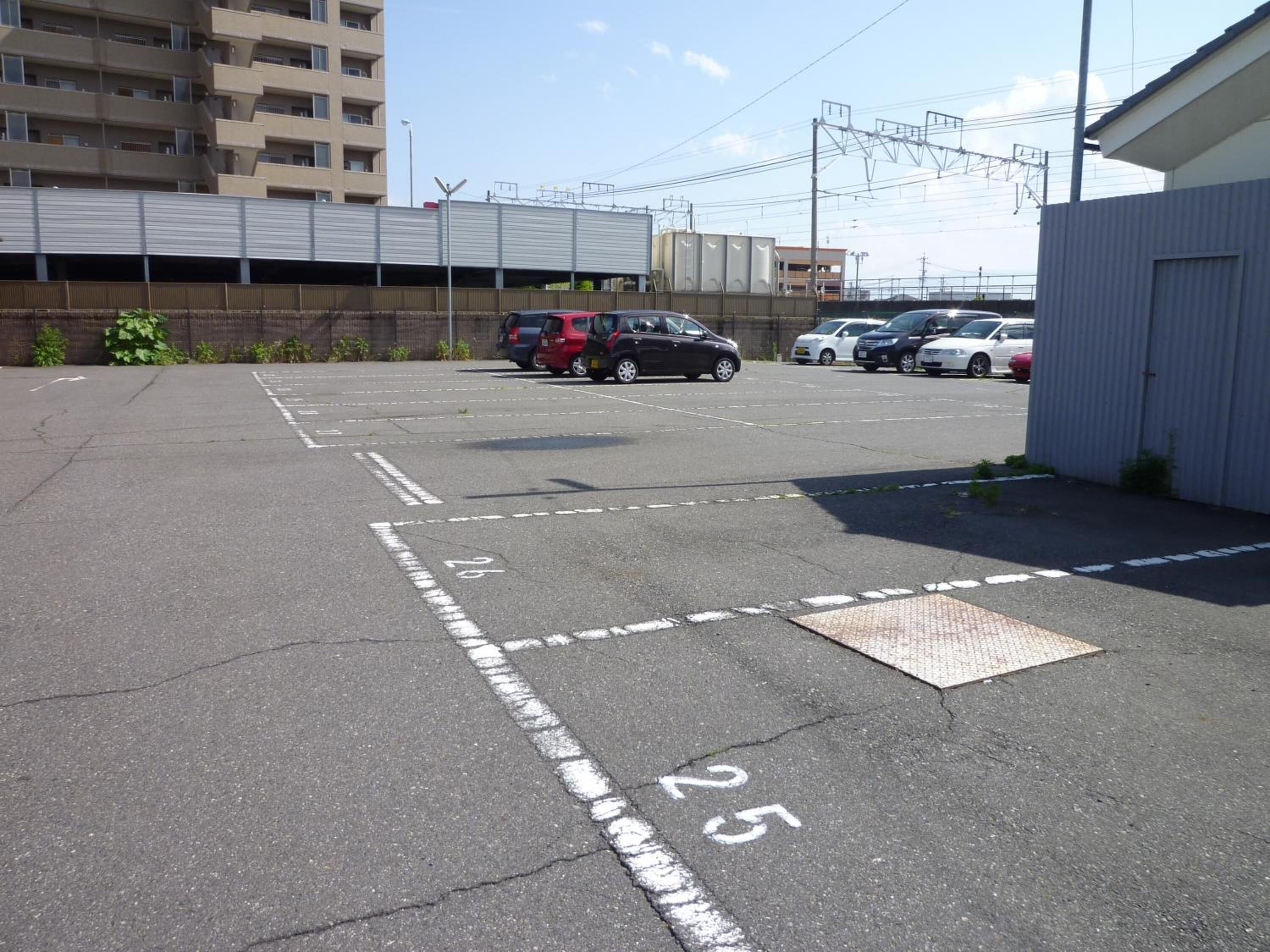 A parking lot with marked spaces and a building in the background.