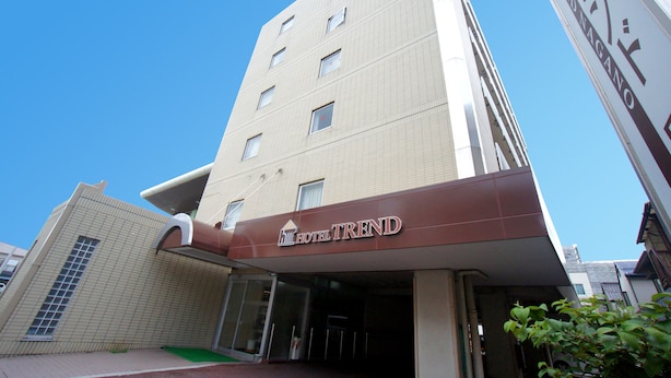 Un hotel con una fachada moderna, varios pisos y una entrada destacada con un letrero que dice "HOTEL TREND".