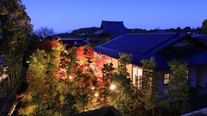 A traditional Japanese house with a tiled roof, surrounded by trees with autumn foliage. - Machiya AOI KYOTO STAY AOI Suites at Nanzenji (Kyoto)