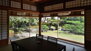 A traditional Japanese room with tatami flooring, a low table, and sliding shoji doors. - Machiya AOI KYOTO STAY AOI Suites at Nanzenji (Kyoto)