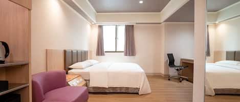 Una habitación de hotel moderna con cama, escritorio, silla y un espejo grande.