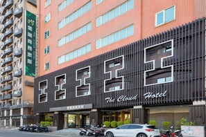 Un hotel con fachada moderna, balcones y un letrero que indica que es The Cloud Hotel.