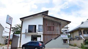 A two-story building with a modern design, featuring a staircase leading to the upper floor and a sign indicating a laundry service.