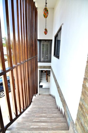 A narrow staircase with a wooden railing and a hanging decorative item. - Highway to H Inn - Danao (Danao)