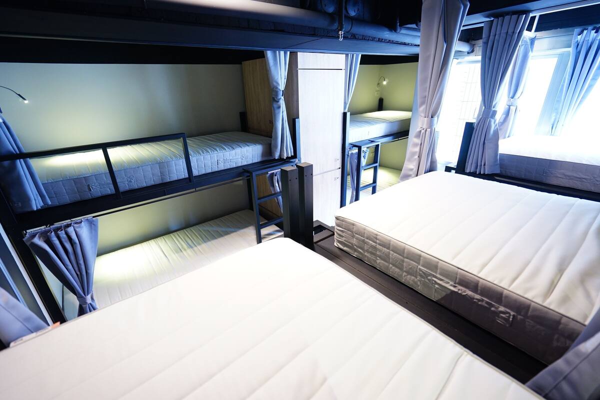 A bunk bed room with a desk and curtains.
