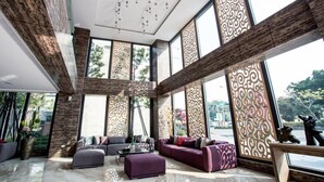 A spacious living area with a large sofa set, a coffee table, and decorative panels. - Imperial Dynasty Exquisite Hotel (Dounan)
