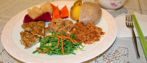 Un plato de comida con carne, verduras y una patata.