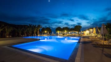 Una piscina al aire libre de temporada, sombrillas