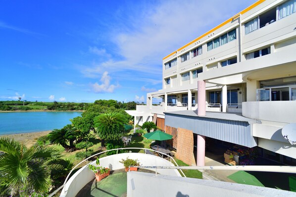 Un hotel con piscina, asientos al aire libre y vistas al agua.
