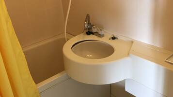 A bathroom with a toilet, sink, and bathtub.
