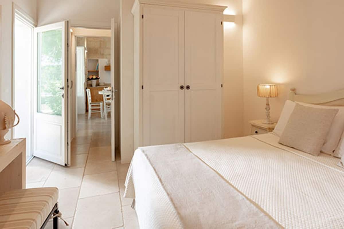Une chambre à coucher avec un lit, une table de chevet, une lampe et une armoire.