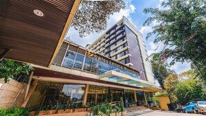A modern hotel with a prominent sign, a covered entrance, and a parking area. - Swiss Lenana Mount Hotel (Nairobi)