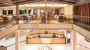 A hotel lobby with a reception desk, seating area, and a glass railing overlooking the lower level. - Swiss Lenana Mount Hotel (Nairobi)
