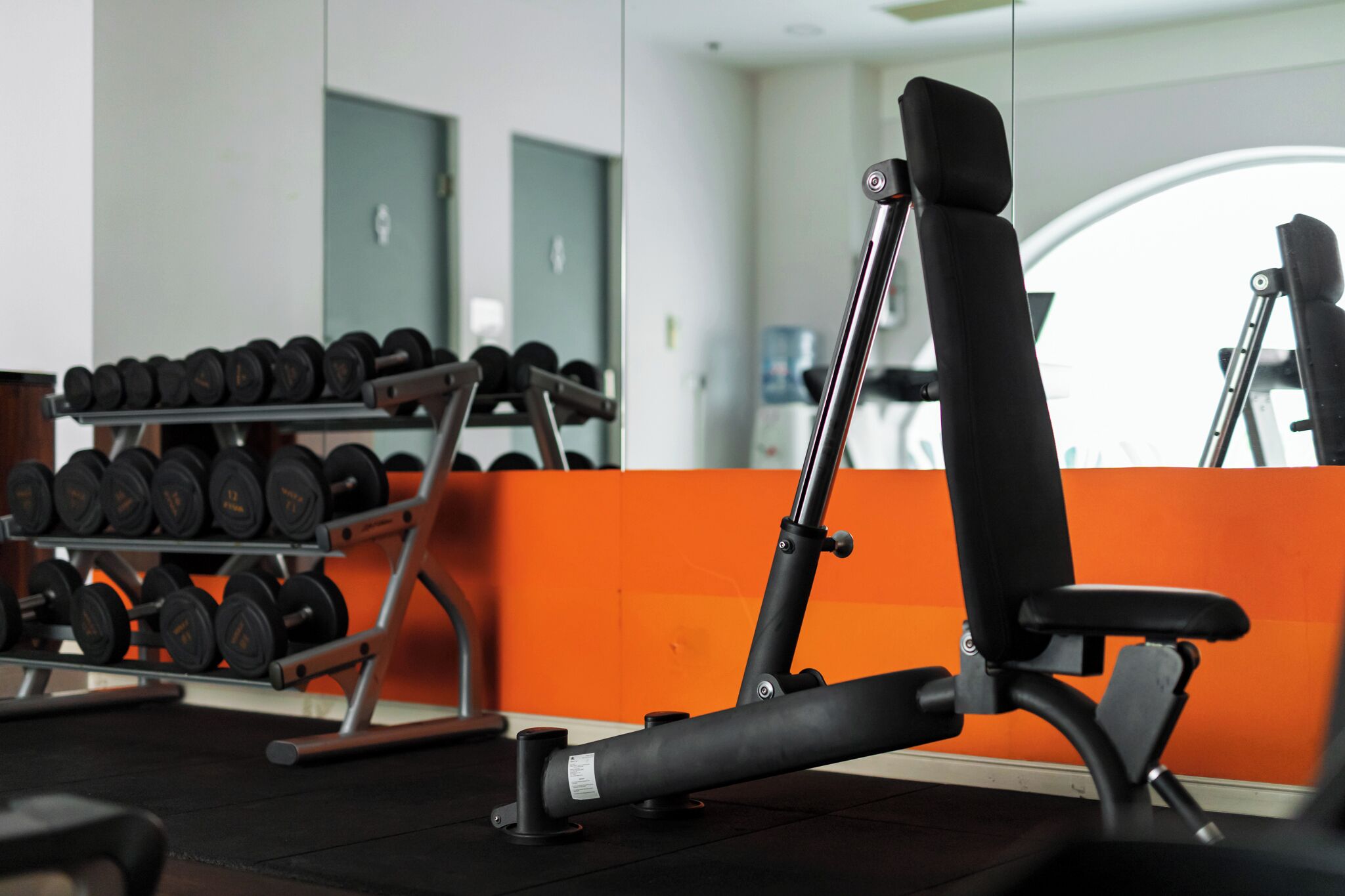 A gym with exercise equipment, including a bench and dumbbells.