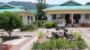Un hotel con techo verde, un espacio al aire libre cubierto con una escultura de piedra y un jardín bien cuidado.