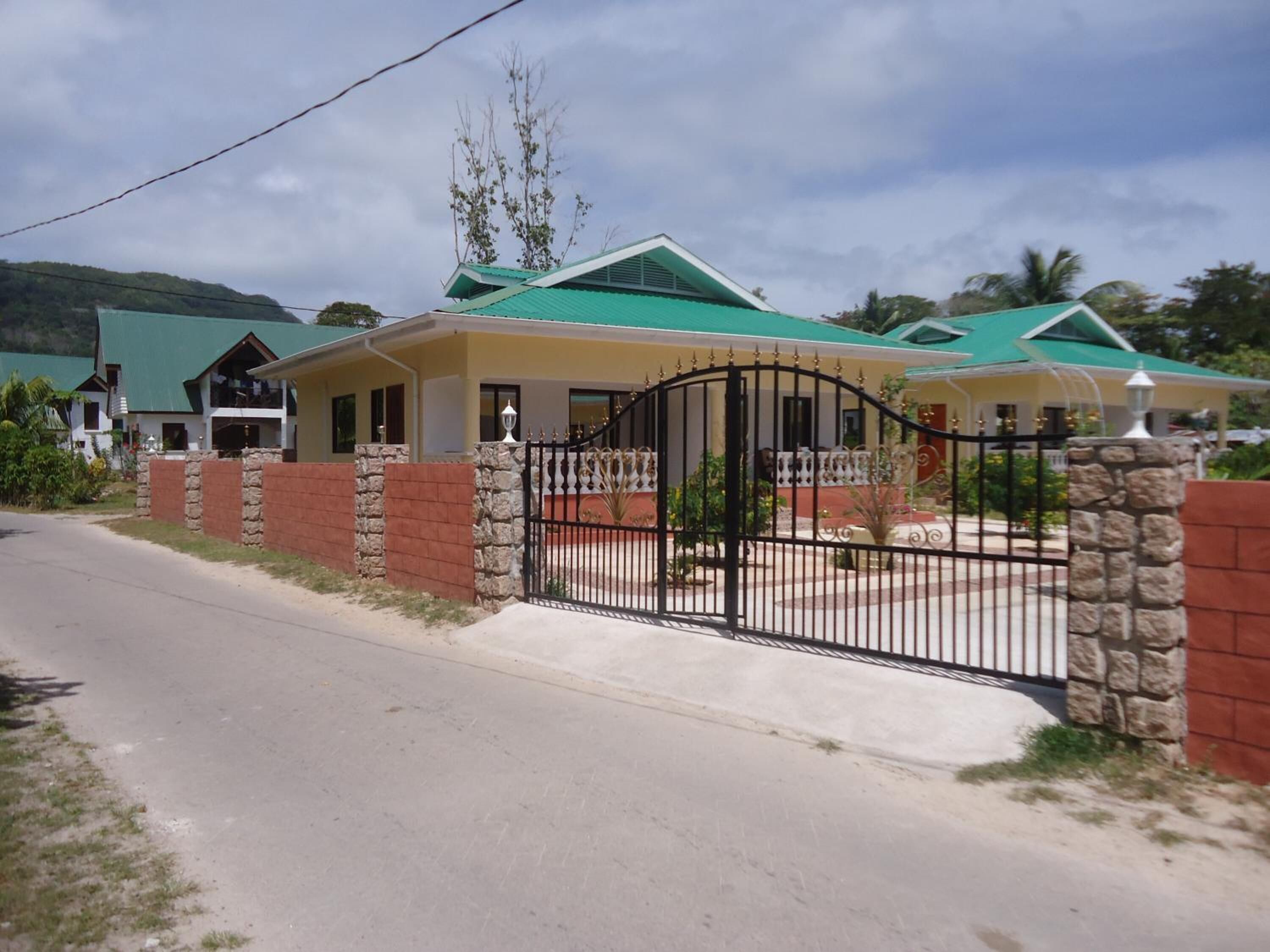 A residential area with houses featuring green roofs and a gated entrance.
